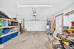 Concrete-floored garage with a white overhead door and an automatic opener - 