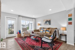 Open Concept Living Room Space featuring Large South Facing Window, Access to Balcony, Electric Fireplace, and Ample Space for Gatherings. - 