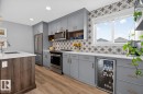 Open Concept Kitchen featuring Stainless Steel Appliances, Stylish Lighting and Accent Tiles, Bar Fridge, and Bar/Counter Seating. - 1051 Cy Becker Road Nw, Edmonton, AB  - Indoor Photo Showing Kitchen With Upgraded Kitchen 