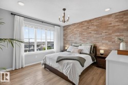 Primary Bedroom Featuring South Facing Windows, Walk in Closet, Ensuite Bathroom, and Decorative Wall Paper. - 