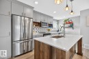 Open Concept Kitchen featuring Stainless Steel Appliances, Stylish Lighting and Accent Tiles, Bar Fridge, and Bar/Counter Seating. - 1051 Cy Becker Road Nw, Edmonton, AB  - Indoor Photo Showing Kitchen With Double Sink With Upgraded Kitchen 