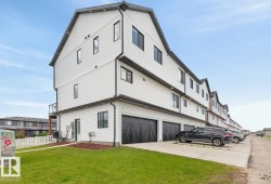 Exterior Back of House featuring Double Garage and Parking Pad. - 