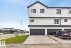 Exterior Back of House featuring Double Garage and Parking Pad. - 