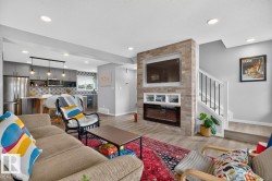 Open Concept Living Room Space featuring Large South Facing Window, Access to Balcony, Electric Fireplace, and Ample Space for Gatherings. - 