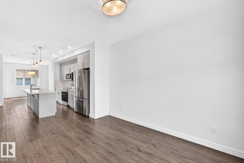 Open-concept kitchen featuring an island with an undermount sink, stainless steel appliances, light-toned cabinetry, and recessed lighting - 1261 Rosenthal Boulevard Nw, Edmonton, AB - Indoor Photo Showing Kitchen