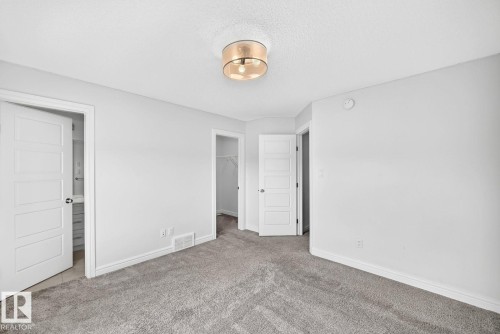 Carpeted room featuring light gray walls and a contemporary ceiling light fixture - 1261 Rosenthal Boulevard Nw, Edmonton, AB - Indoor Photo Showing Other Room