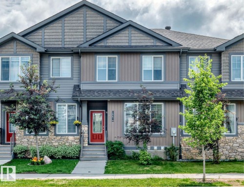 Townhouse exterior featuring a red entry door, gray siding, stone accents, and a gabled roofline - 1261 Rosenthal Boulevard Nw, Edmonton, AB - Outdoor With Facade