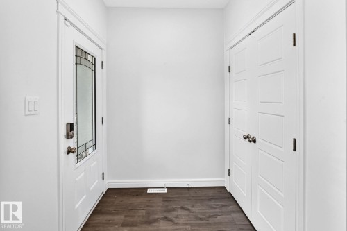 Entryway featuring a white paneled door with decorative glass insert and dark hardware - 1261 Rosenthal Boulevard Nw, Edmonton, AB - Indoor Photo Showing Other Room
