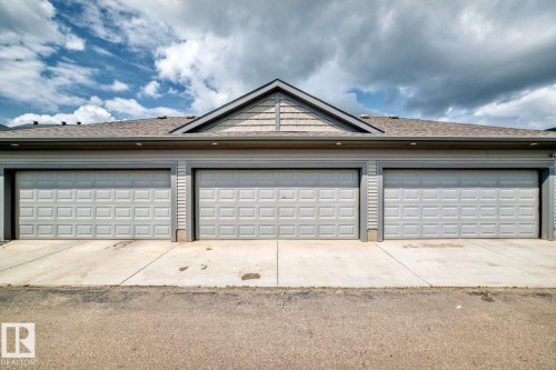 Three-stall garage with panel-style doors and concrete driveways - 1261 Rosenthal Boulevard Nw, Edmonton, AB - Outdoor