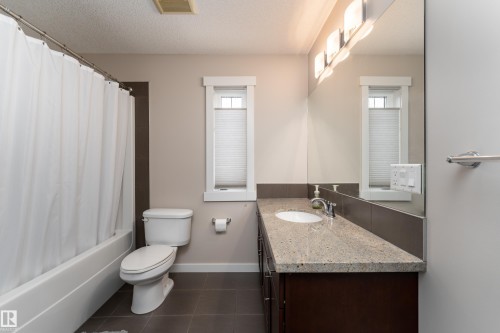 Bathroom featuring a white tub and shower combination, a toilet, and a vanity with an integrated sink - 2338 Frezenberg Avenue Nw, Edmonton, AB - Indoor Photo Showing Bathroom