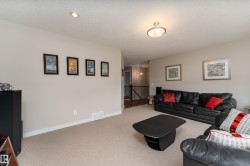 Carpeted living area featuring recessed lighting, a ceiling-mounted light fixture, light gray wall paint, and white baseboards - 