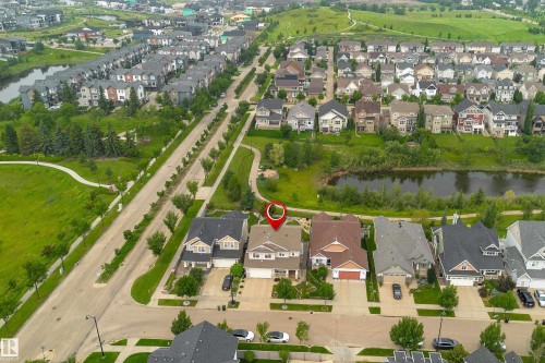 Aerial perspective showcasing a residential area with a prominent pond and green spaces - 2338 Frezenberg Avenue Nw, Edmonton, AB - Outdoor With Body Of Water With View