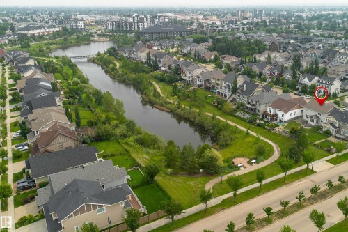 Residential area featuring a winding waterway, green spaces, and a paved pathway system - 2338 Frezenberg Avenue Nw, Edmonton, AB - Outdoor With Body Of Water With View