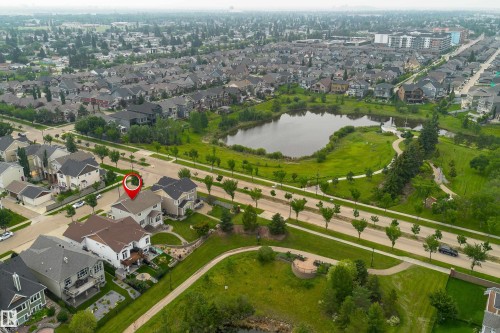 Aerial perspective showcasing a residential area with a prominent pond and green spaces - 2338 Frezenberg Avenue Nw, Edmonton, AB -  With View