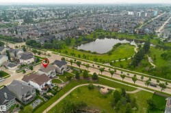 Aerial perspective showcasing a residential area with a prominent pond and green spaces - 