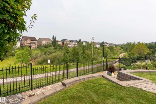 Landscaped backyard featuring paver stone patio, stone retaining walls, and a manicured lawn - 2338 Frezenberg Avenue Nw, Edmonton, AB - Outdoor