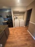 Dedicated laundry area featuring a washer and dryer, adjacent to an open shelving system - #206 2311 119 St Nw, Edmonton, AB  - Indoor Photo Showing Laundry Room 