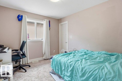 Bedroom featuring carpet flooring, a window with vertical blinds, a ceiling-mounted light fixture, a white interior door, and light-toned wall finishes - 258 Albany Drive Nw, Edmonton, AB - Indoor Photo Showing Bedroom