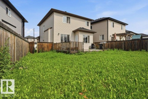 Expansive backyard featuring a wood deck, sliding glass door access, and a bay window - 258 Albany Drive Nw, Edmonton, AB - Outdoor