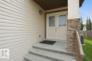Entryway featuring double doors with decorative glass panels, stone veneer pillar, concrete steps, and a metal handrail - 258 Albany Drive Nw, Edmonton, AB  - Outdoor With Exterior 