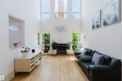 Two-story living room featuring high ceilings and light wood-finish flooring - 