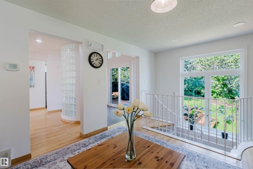 Hardwood flooring extends throughout the main level, complemented by a curved glass block partition - 342 O'Connor Close Nw, Edmonton, AB - Indoor