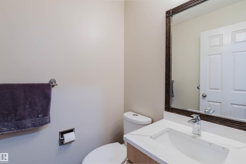 Bathroom featuring a white vanity with an integrated sink, polished chrome faucet, and a framed mirror - 342 O'Connor Close Nw, Edmonton, AB - Indoor Photo Showing Bathroom