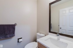 Bathroom featuring a white vanity with an integrated sink, polished chrome faucet, and a framed mirror - 
