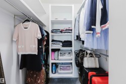 Walk-in closet featuring built-in shelving, chrome hanging rods, and white walls - 