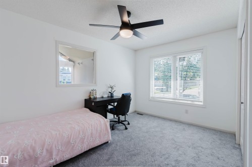 Bedroom featuring light gray carpeting, crisp white walls, a large window with white blinds, and a contemporary ceiling fan with integrated lighting - 342 O'Connor Close Nw, Edmonton, AB - Indoor Photo Showing Bedroom