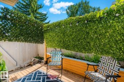 Outdoor deck featuring wood flooring and a privacy hedge - 