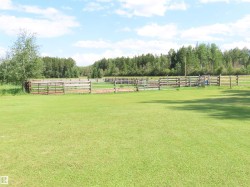 Expansive green lawn with a perimeter of wood fencing - 