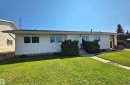 Single-story residence featuring a white stucco exterior, multiple front-facing windows, and a concrete walk leading to the entrance - 5201 54 Street, Elk Point, AB  - Outdoor 
