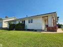 Ranch-style exterior featuring a stucco facade and a partial stone accent wall with brick details - 5201 54 Street, Elk Point, AB  - Outdoor 