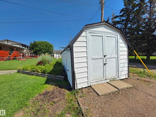 White vinyl-sided shed with a dark trim and a gable roof - 5201 54 Street, Elk Point, AB - Outdoor With Exterior
