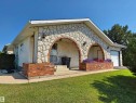 Stone facade home featuring two arched entryways with exterior lighting - 5201 54 Street, Elk Point, AB  - Outdoor 