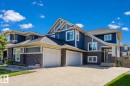 Contemporary facade featuring blue siding, stone accents, multiple gables, and an attached two-car garage - 4125 Kennedy Green Sw, Edmonton, AB  - Outdoor With Facade 