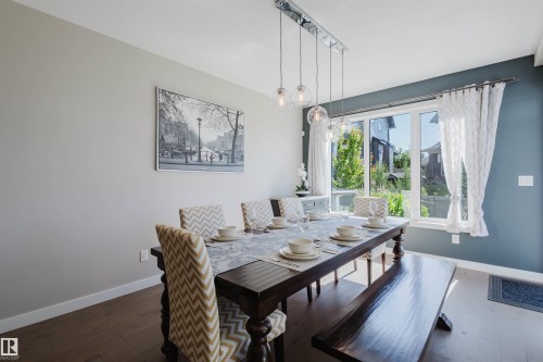Dining area with wood-finish flooring and a multi-pane window - 4125 Kennedy Green Sw, Edmonton, AB - Indoor Photo Showing Dining Room