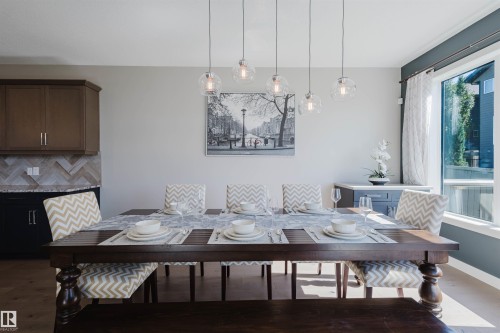 Dining area featuring a dark wood-finish table and coordinated bench seating - 4125 Kennedy Green Sw, Edmonton, AB - Indoor Photo Showing Dining Room