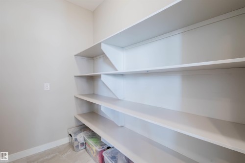 Built-in shelving unit with multiple levels, light-toned walls, and neutral flooring - 4125 Kennedy Green Sw, Edmonton, AB - Indoor With Storage