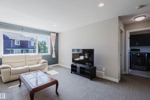 Living area with a wide window, recessed lighting, and patterned carpeting - 4125 Kennedy Green Sw, Edmonton, AB - Indoor Photo Showing Living Room