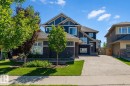 Contemporary two-story residence featuring a dark blue exterior with stone accents and white trim - 4125 Kennedy Green Sw, Edmonton, AB  - Outdoor With Facade 