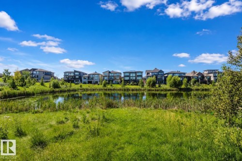 Waterfront properties featuring modern architecture and lush green surroundings - 4125 Kennedy Green Sw, Edmonton, AB - Outdoor With View