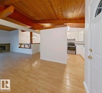 Wood-finish flooring throughout, complemented by a wood-paneled and exposed beam ceiling - 