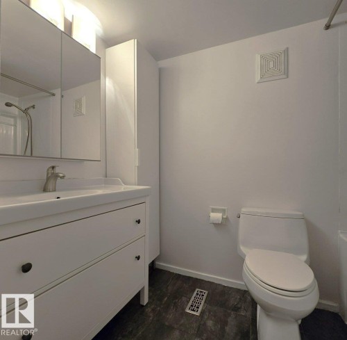 Bathroom featuring a white vanity with integrated sink, brushed nickel faucet, and a mirrored medicine cabinet - 60 Northwoods Village Nw, Edmonton, AB - Indoor Photo Showing Bathroom