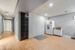 Open concept lower level featuring light wood-finish flooring, recessed lighting, and a utility sink - 