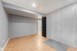 Room featuring wood-finish flooring, recessed lighting, and a textured accent wall - 