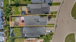 Aerial perspective highlighting the property with a distinct rear deck and patio area - 