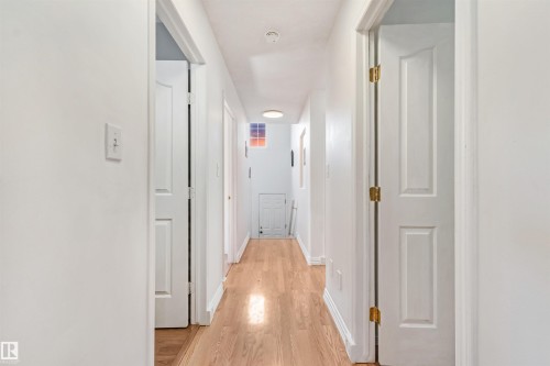 Bright hallway featuring light wood-finish flooring and white walls - 16737 116 Street Nw, Edmonton, AB 