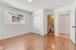 Light wood-finish flooring with white baseboards throughout - 